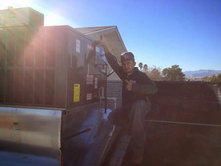 HVAC technician performing Boiler Repair on a rooftop unit in Parma
